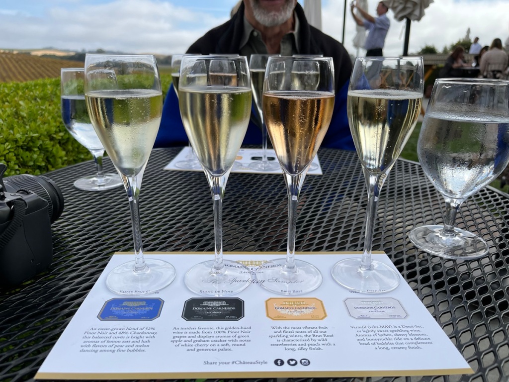 four glasses of sparkling win on a table, with name sheet in front