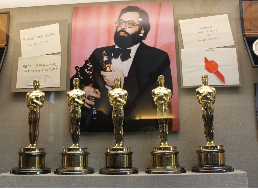 five Oscar statures in a glass case, with photo of Coppola be